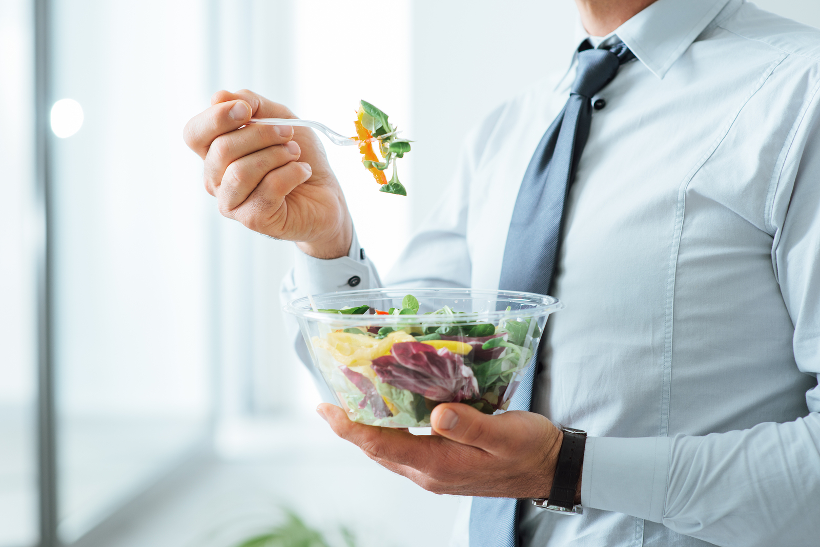 Businessman holding fresh salad bowl
