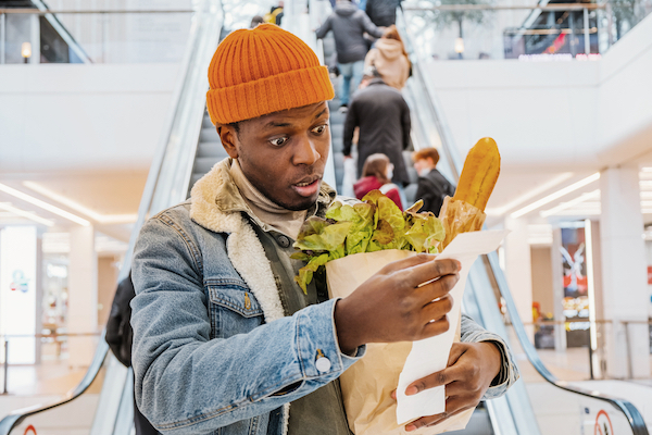 African,Man,With,A,Paper,Bag,Of,Groceries,Looks,Surprised