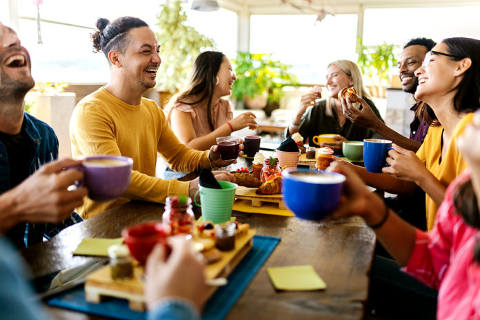 Smiling Group Of Diverse Friends Having Breakfast And Talking At