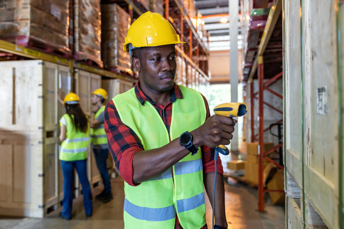Portrait of african black warehouse worker hold hand scanner to