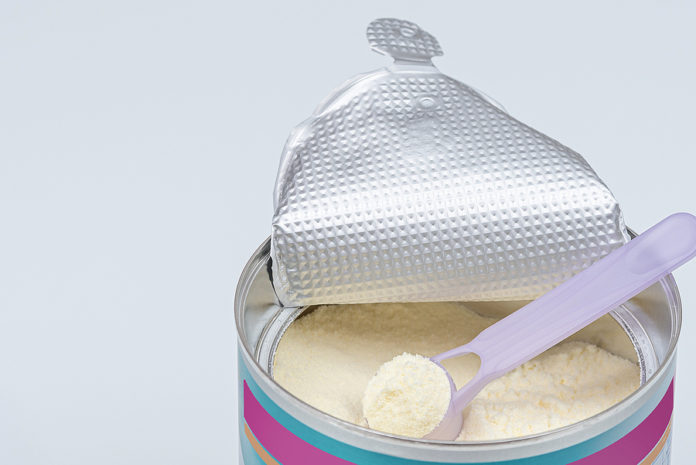 Infant Formula In Spoon. High Angle View Of Baby Formula And Spo