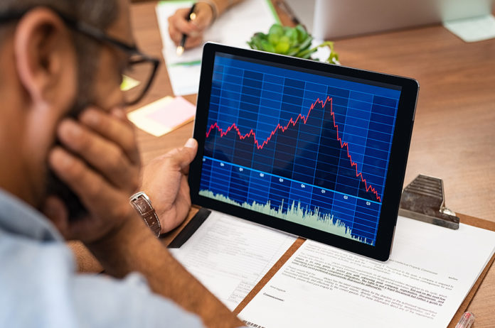 Closeup of a stock market broker working with graphs on digital