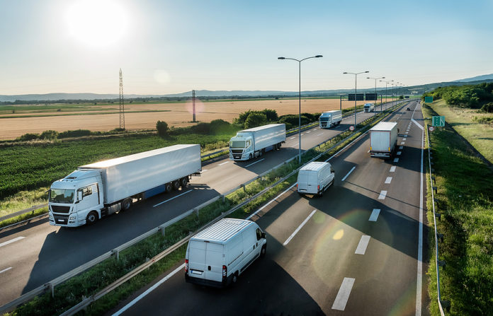 Convoy Or Caravans Of Transportation Trucks Passing Vans And Tru