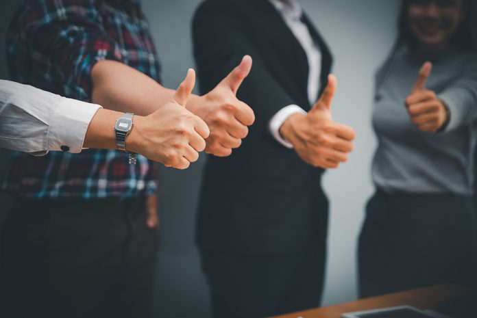 Group Of Business People Giving Thumb Up After Sucess Deal With