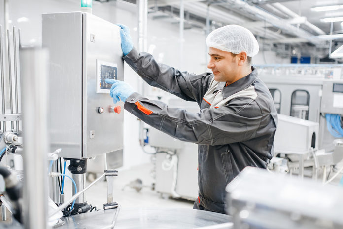 Factory Engineer Man Operating Machine Control Panel In Dairy Mi