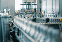 Companies Are Closing Plants and Cutting Jobs Based on These Four Figures Production Line Transports Empty Glass Bottles For Alcohol Drink