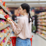 Still Worried About Inflation, Consumers Look for Deals woman choosing products in grocery store