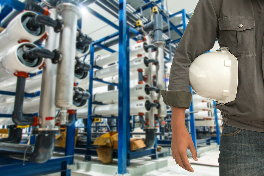 Engineering and safety helmet standing on the details of the food manufacturing industry, water purification station.