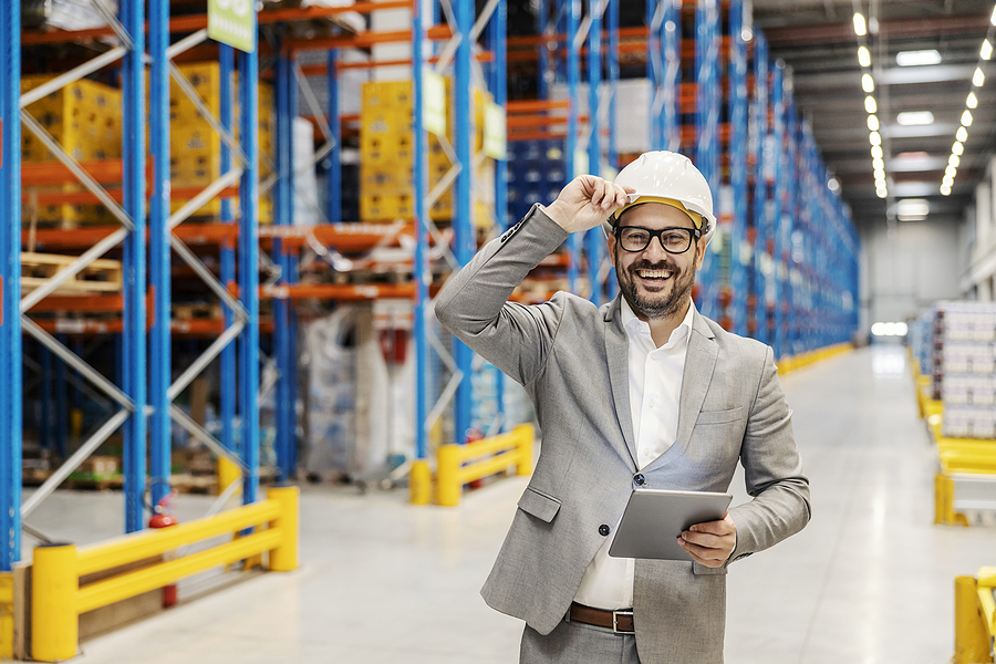 A Storage Worker Is Tracking Goods And Inventory While Holding T