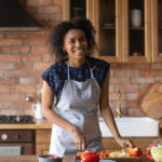 Early Adopter Consumers Seek Cooking Tips and Easy Meals: Curious Plot Joyful Young Afro American Lady Cut Vegetable Salad For Lunch