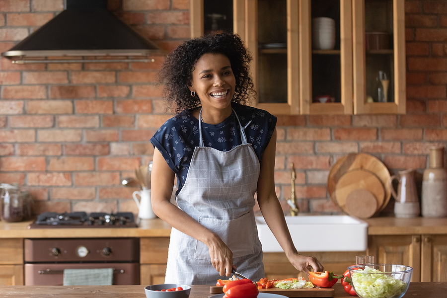 Joyful Young Afro American Lady Cut Vegetable Salad For Lunch