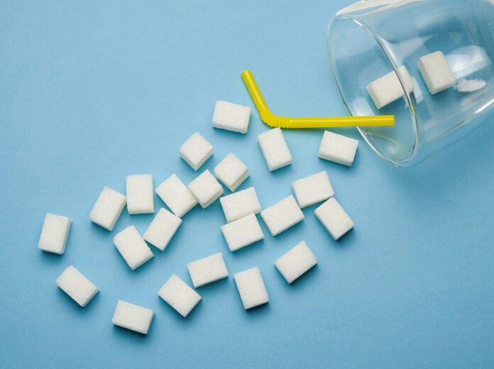 Sugar Cubes In Glass Cup On The Pastel Blue Background. Concept