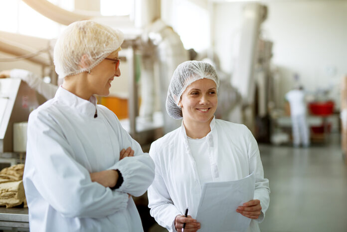Two Young Gorgeous Female Workers Are Having A Chat While One Of