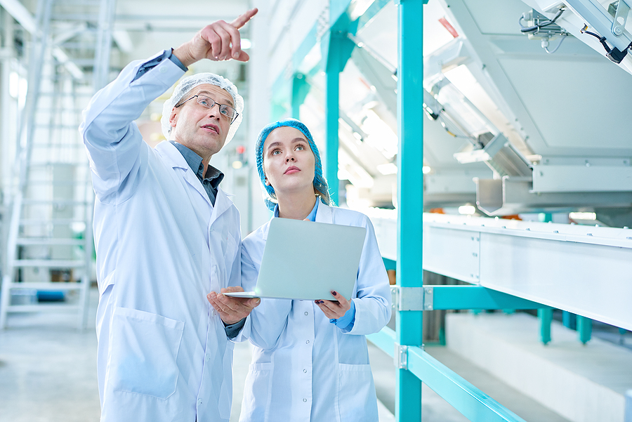 Portrait Of Senior Factory Worker Wearing Lab Coat Explaining Ru