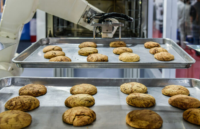 Robot Arm Preparing Cookies For The Oven In Production Line Fact