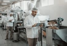 Replacing the Clipboard: Digitizing Compliance on the Factory Floor 1176094666_supervisor-evaluating-quality-food-food-plant-while-holding-tablet-Dayinlife-FoodBev_Getty